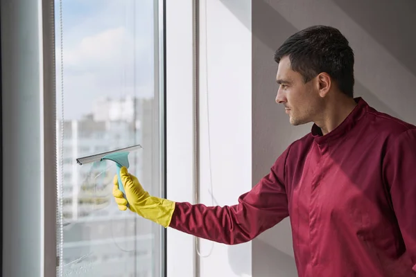 Housecleaner limpeza superfície de vidro usando ferramenta com lâmina de borracha — Fotografia de Stock