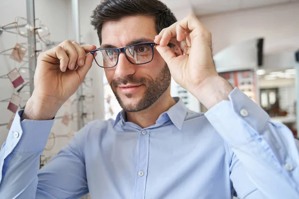 Вміст чоловіка, який дивиться через нові окуляри — стокове фото
