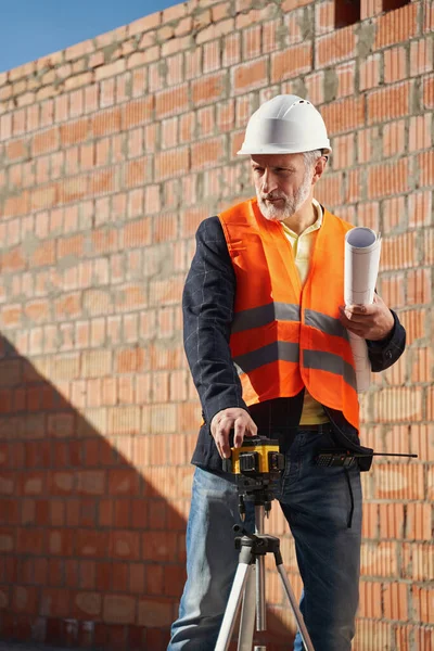 Professionell ingenjör med lasernivå i sitt arbete — Stockfoto