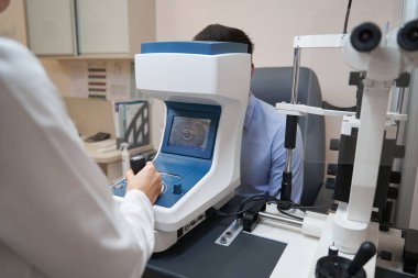 Göz hekimi otomatik fraktör ile insan görüşünü kontrol ediyor.