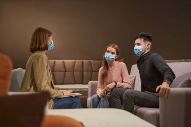 Nitelikli mağaza asistanına danışan iki potansiyel müşteri