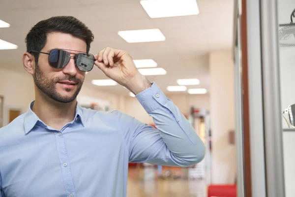 El joven feliz está ajustando sus gafas de sol. — Foto de Stock