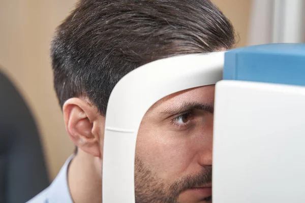 Αρσενικός ασθενής που εξετάζει αυτοδιαθλαστικό κατά την οφθαλμολογική εξέταση — Φωτογραφία Αρχείου
