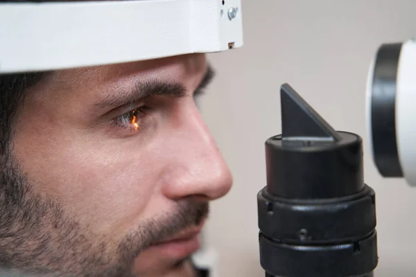 Hombre mirando la luz de la lámpara de hendidura durante la inspección ocular — Foto de Stock
