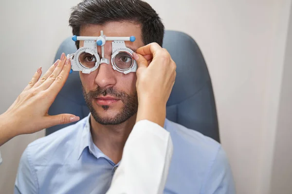 Médico ocular insertando lente en el marco del ensayo — Foto de Stock
