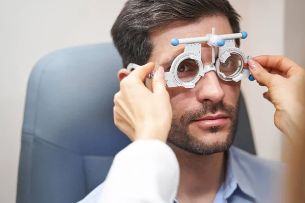 Οφθαλμίατρος που εκτελεί πλευρική ρύθμιση γωνίας του πλαισίου δοκιμής — Φωτογραφία Αρχείου