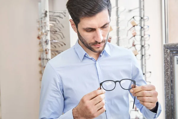 Άνδρας πελάτης ρίχνει μια ματιά σε γυαλιά — Φωτογραφία Αρχείου