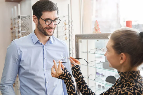 Verkäuferin im Optikergeschäft bietet zufriedenen Kunden Brille an — Stockfoto