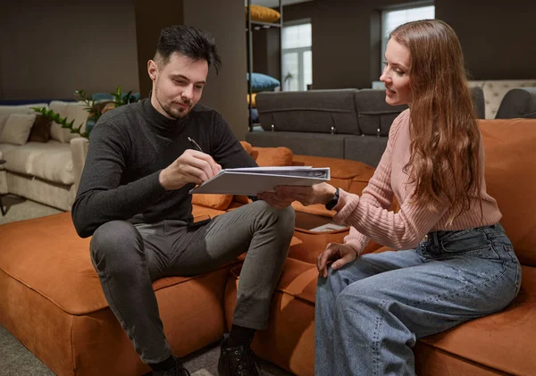 Couple buying new piece of furniture in shop