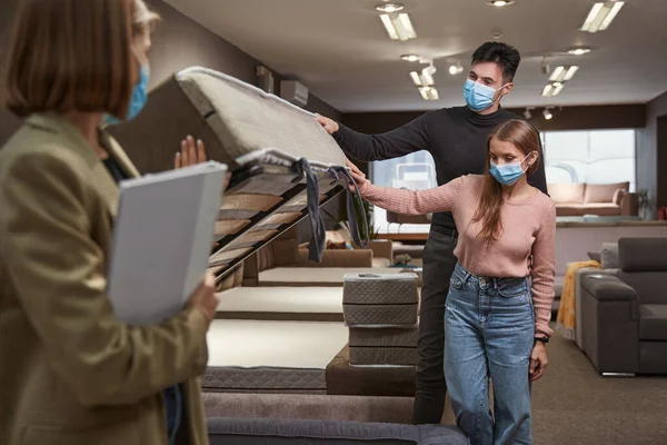 Dos compradores concentrados comprando sofá cama plegable — Foto de Stock