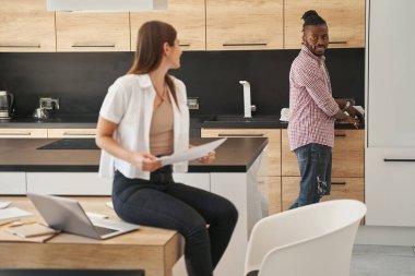 Memnun bir adam elinde belgelerle kadına bakıyor.