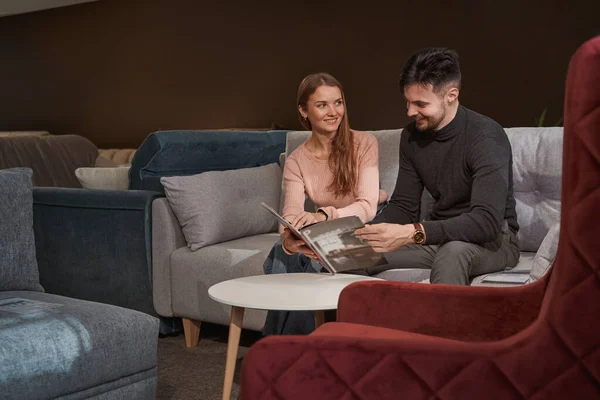 Glimlachende vrouw en man kiezen nieuwe meubels — Stockfoto