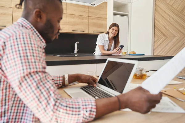 Glimlachende vrouw kijken naar ernstige man op laptop — Stockfoto