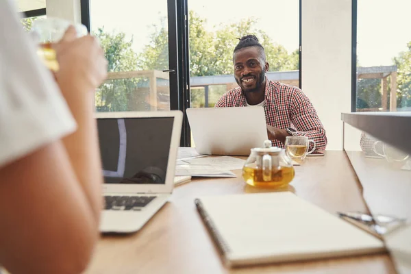 Vreugdevolle man praat met zijn collega bij de thee — Stockfoto