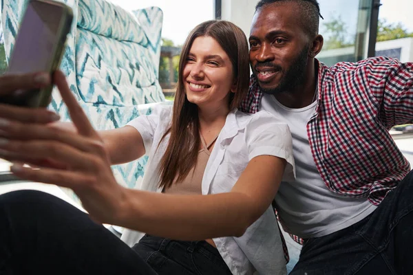 Paar zittende in de kamer het nemen van smartphone foto 's — Stockfoto