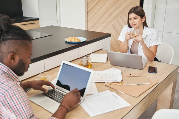 Vrouw kijken jonge man typen notebook computer — Stockfoto