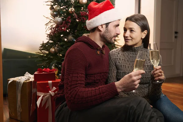 Lovers sitting on the living room floor and celebrating Christmas — Stock Photo, Image