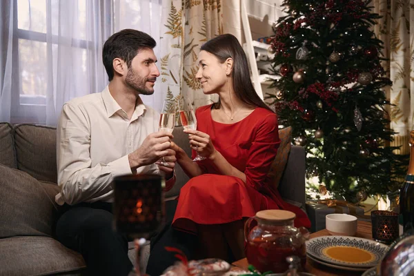 Ευτυχισμένος άνδρας και γυναίκα τσούξιμο ποτήρια κατά τη διάρκεια τοστ την παραμονή των Χριστουγέννων — Φωτογραφία Αρχείου