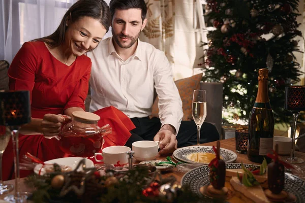 Happy couple in love drinking tea together on Christmas — Stockfoto