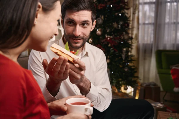 Hombre sosteniendo pedazo de pastel e invitando a su novia a comerlo — Foto de Stock