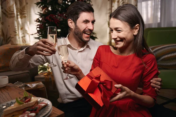 Пара пьет вино и празднует Рождество вместе дома — стоковое фото