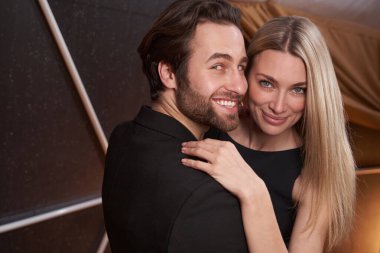 Aşık çift dans ederken kameraya gülümsüyor