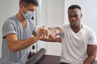 Dirençli izometrik test sırasında fizyoterapist tarafından muayene edilen hasta