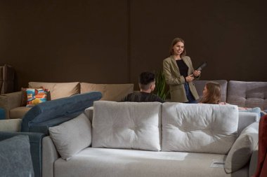 Potansiyel müşterilerin önünde duran neşeli satış asistanı