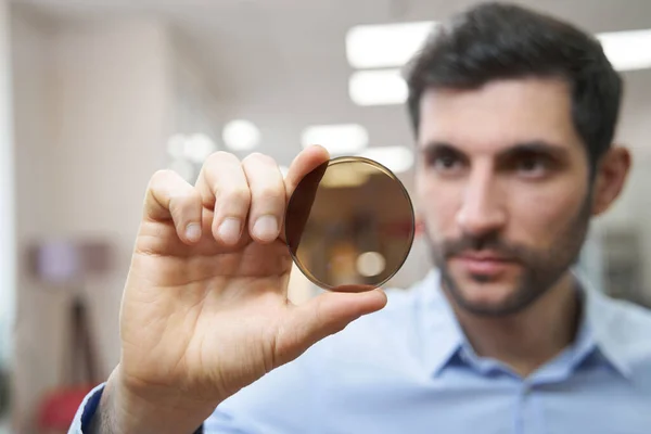 Male holding optical lens of yellow color — 图库照片