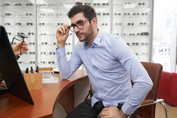 Cliente mirando su cara en el espejo con gafas — Foto de Stock