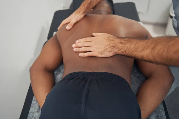 Homem de costas massageado por massoterapeuta profissional — Fotografia de Stock
