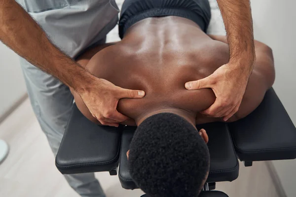 Чоловік пацієнта, який масажується кваліфікованим масажистом — стокове фото