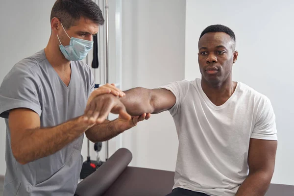 Young man having his muscle strength assessed — Stockfoto