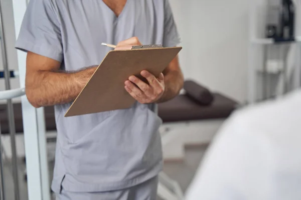 Médico de pie ante su paciente durante la consulta médica — Foto de Stock