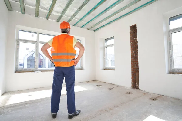 Male builder in room with back to camera — Stockfoto