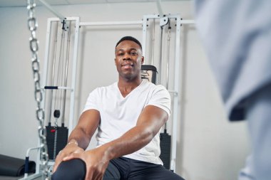 Spor salonunda bacak egzersizi yapan bir adam.