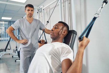 Spor aletlerini kullanarak egzersiz yapan bir adam.
