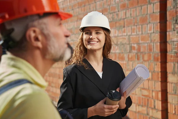 Friendly civil engineer smiling to construction worker — Stockfoto
