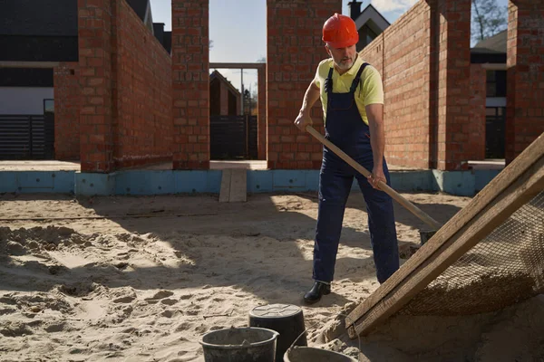 Man byggmästare arbetar med spade på byggarbetsplats — Stockfoto