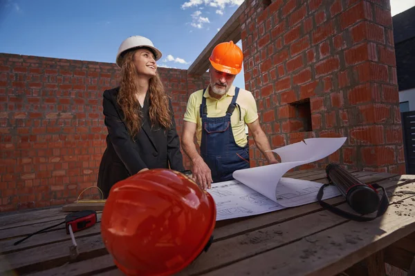 Проверка чертежей, выполненная женщиной-инженером и строителем — стоковое фото