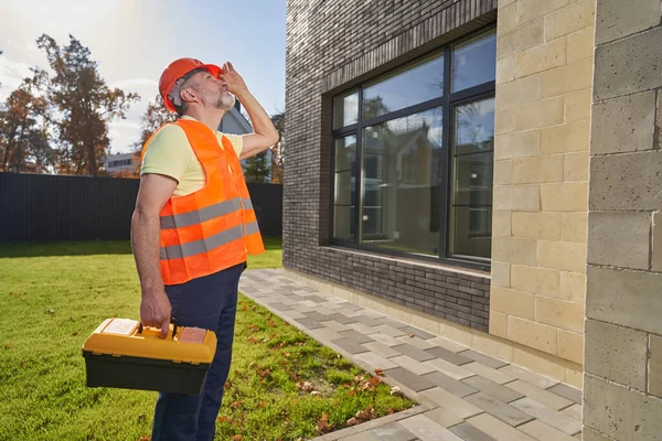 Construction person with instrument box inspecting house — Stockfoto