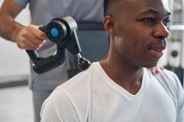 Tranquilo hombre afroamericano sometido a terapia percusiva — Foto de Stock