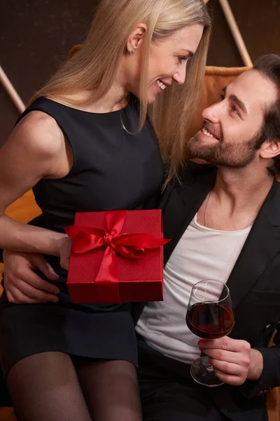 Vrouw glimlacht naar haar man terwijl ze op zijn schoot zit — Stockfoto