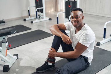 Pleased athlete posing for camera in fitness club