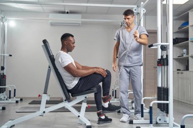 Physiotherapist using fitness equipment for patient rehabilitation