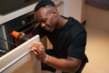 Man with drill working on attaching handle to drawer