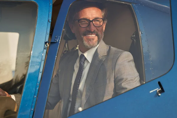Joyful mature man sitting in private chopper — Stockfoto