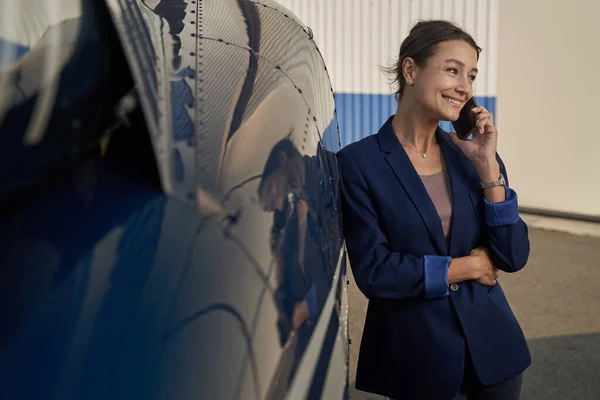 Pleased businesswoman talking on smartphone at heliport — 스톡 사진