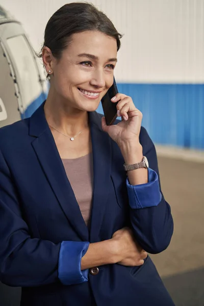 Cheerful elegant entrepreneur talking on cellphone at heliport — Stock Photo, Image