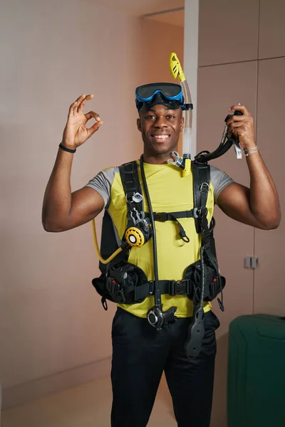 Enthusiastic man standing in diving suit in room — Foto Stock